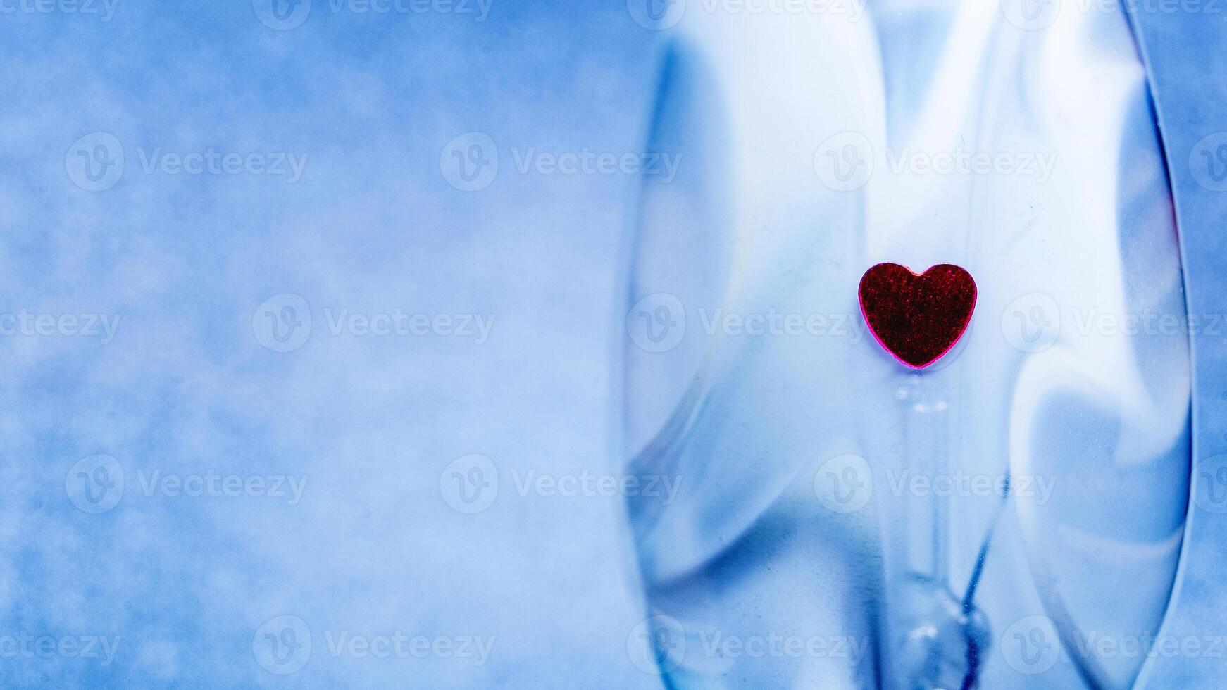 Plain blue background with little red heart photo