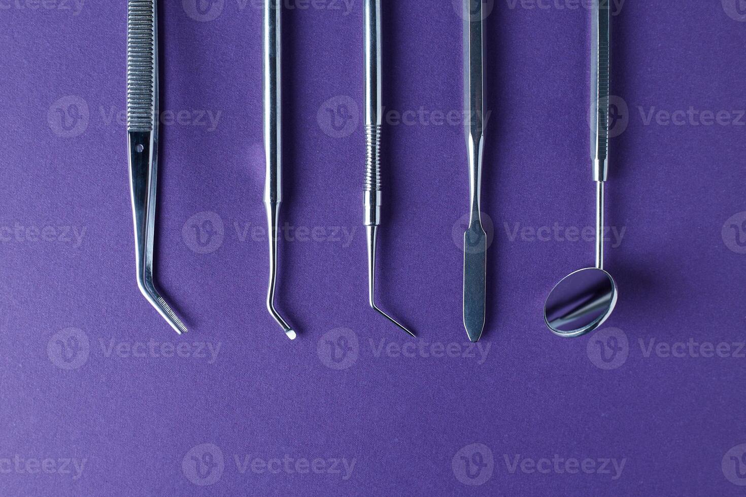 Dental tools on violet background photo