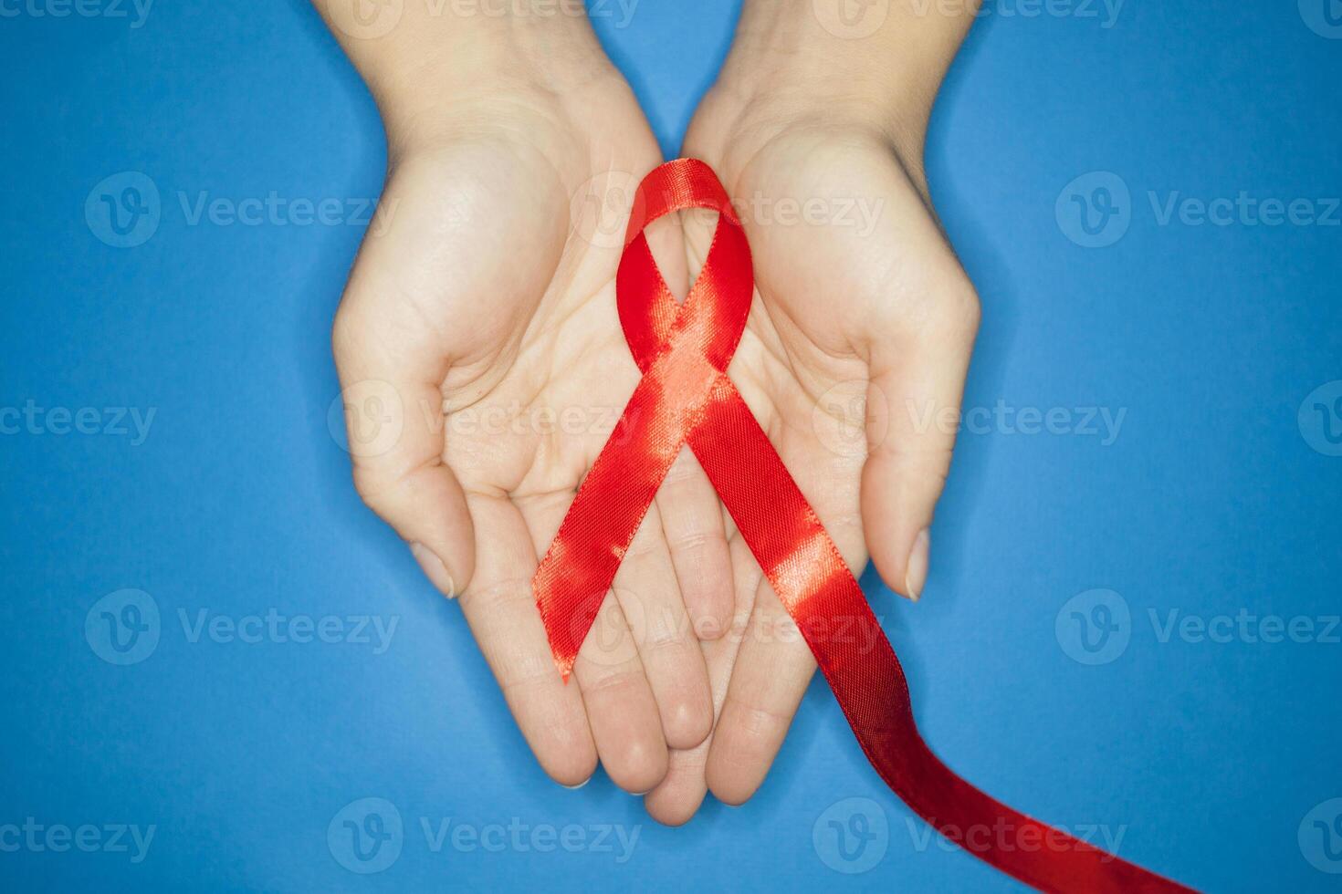 healthcare and medicine concept. Aids Awareness. red AIDS awareness ribbon on blue background from above. copyspace for your individual text. photo