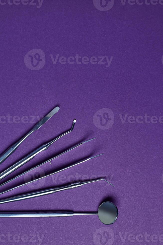 Dental tools on violet background photo