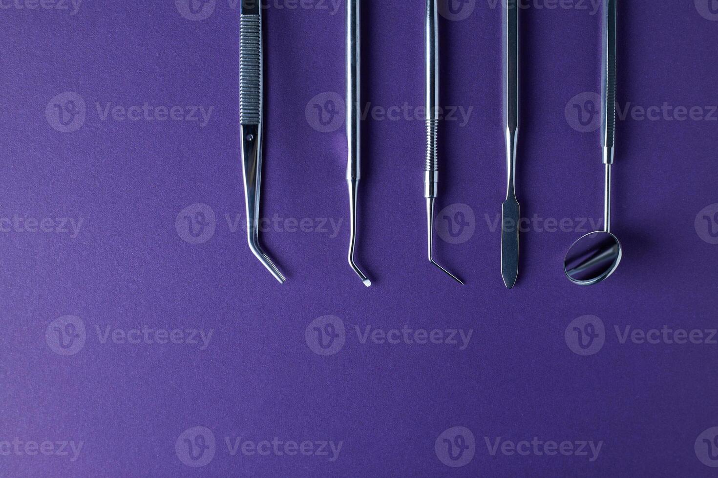 Dental tools on violet background photo