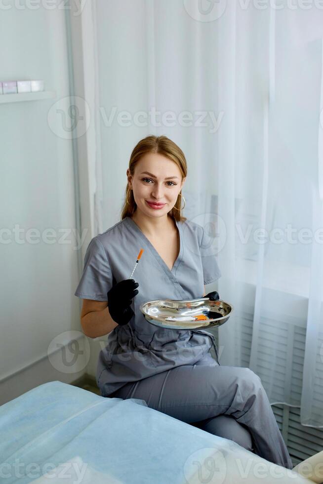 Portrait of a cosmetologist in the office with a syringe. Injection procedure for lip augmentation. Advertising concept for facial care, youth and beauty. photo