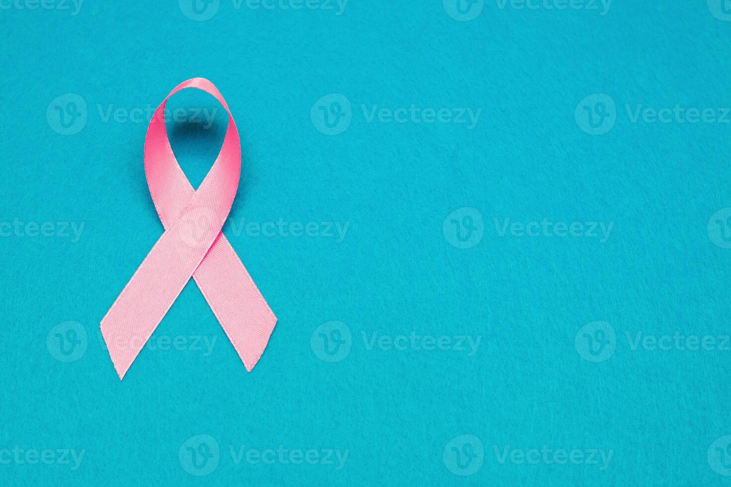 Pink ribbon for breast cancer awareness, symbolic bow color raising awareness on people living with women's breast tumor illness. bow isolated with clipping blue background photo