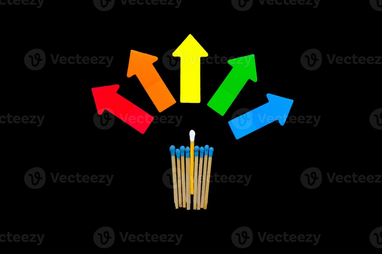 Multi-colored matches on a black background with arrows symbolizing the right to choose. Inclusion. photo