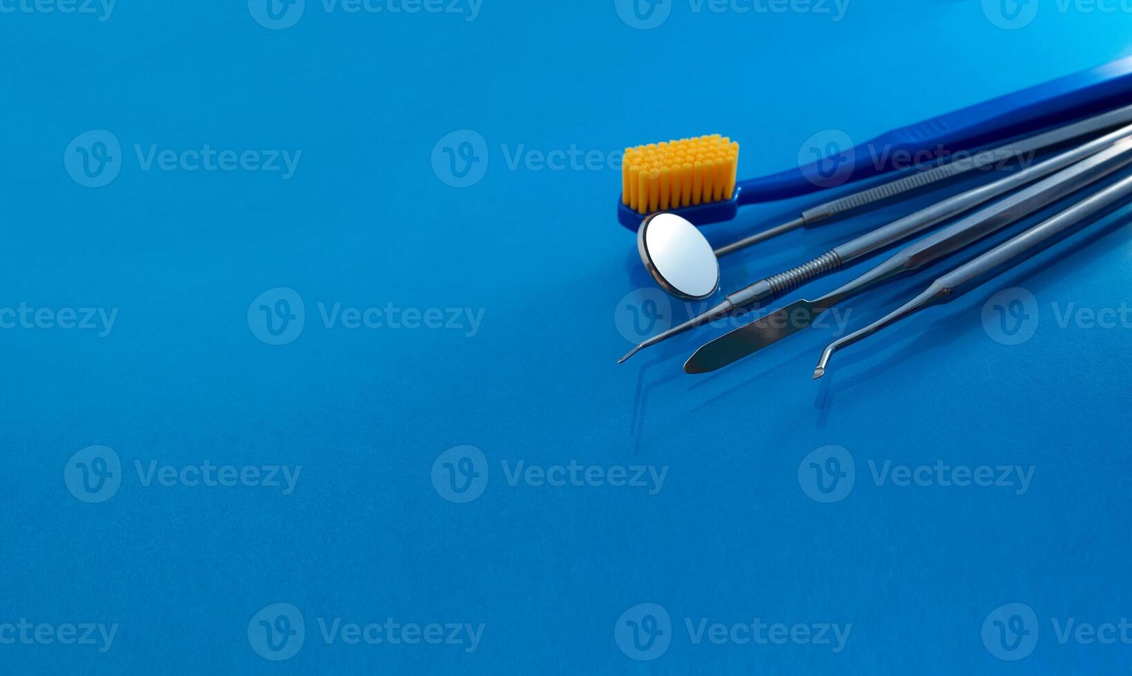 Dental tools use for dentist on the blue background, flat lay, top vipw. photo