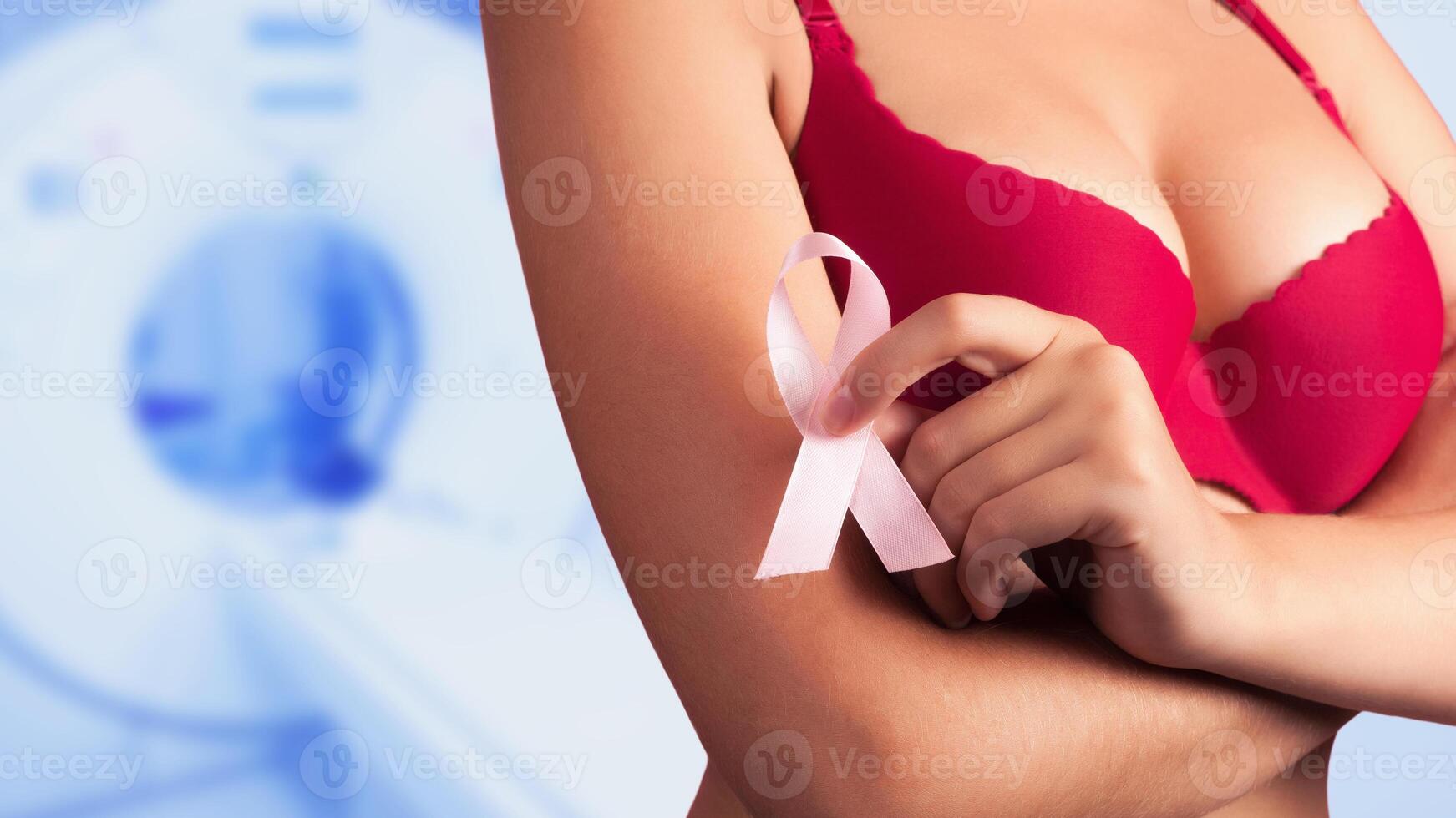 Young woman examining her breast for lumps or signs of breast cancer. Pink Ribbon. isolated on white background photo