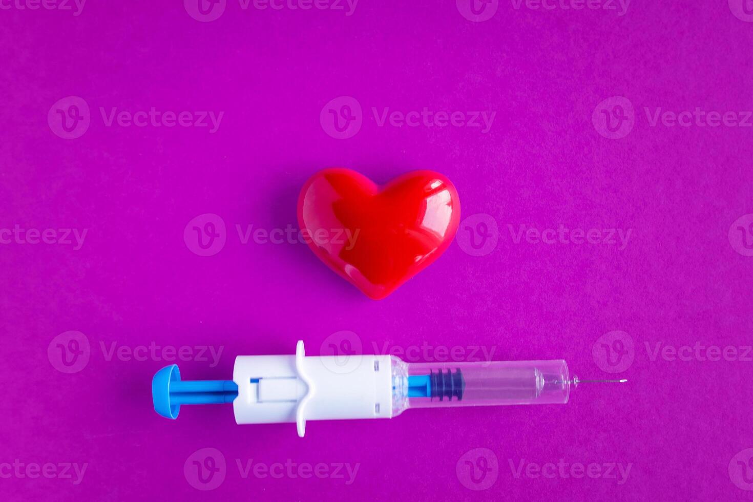 volumetric heart with syringes on a pink background. The concept of supporting patients with heart disease photo
