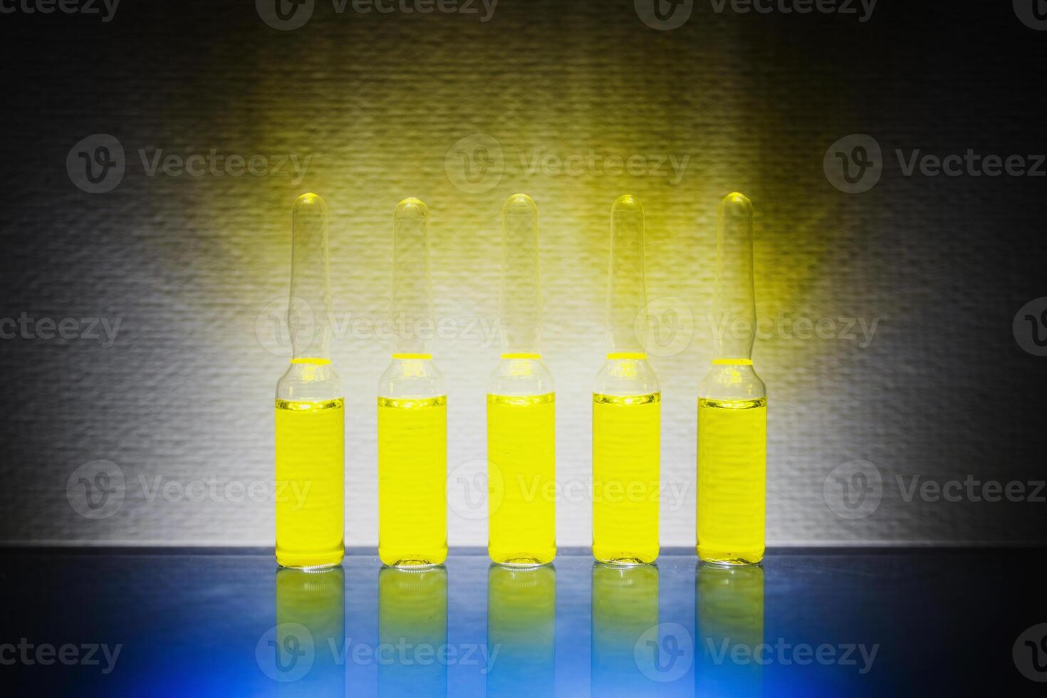 yellow narcotic drugs, chemicals, vitamins in ampoules on a white background photo