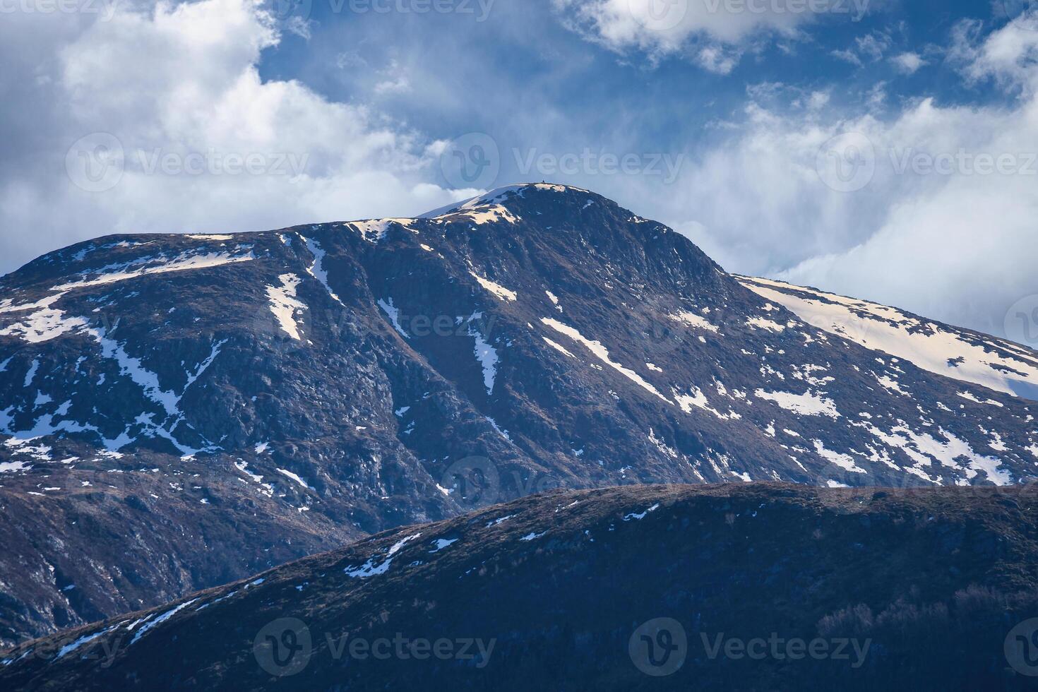 Western cap in Norway. Snow-covered mountain peaks. Very cloudy sky. Landscape photo