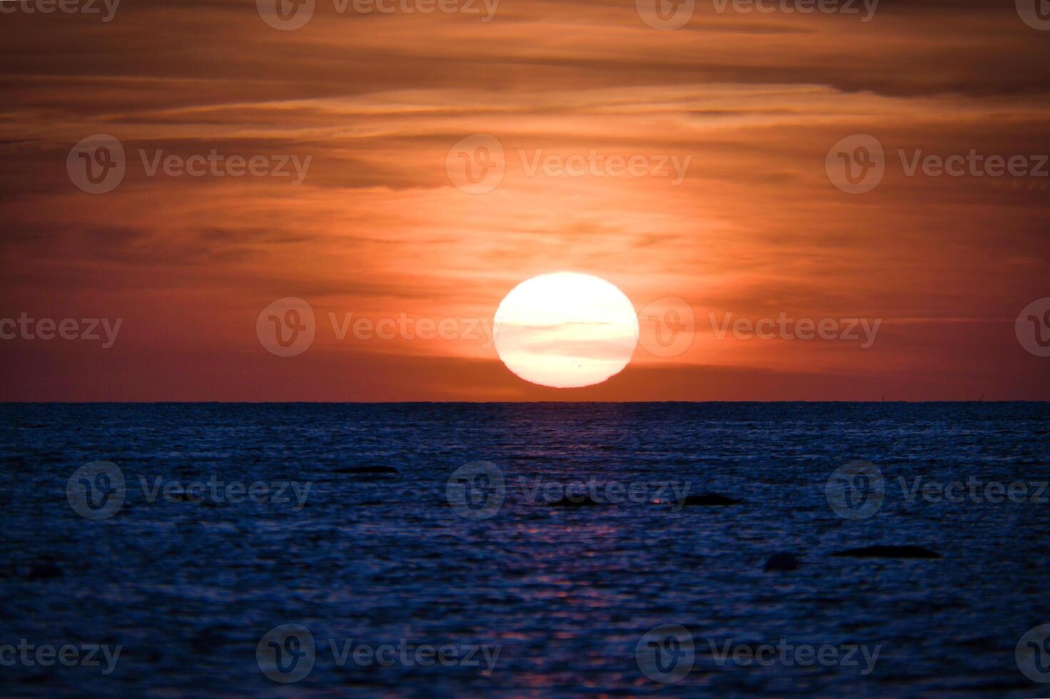 Sunset over the Baltic Sea. The red sun sinks into the sea. Evening atmosphere photo