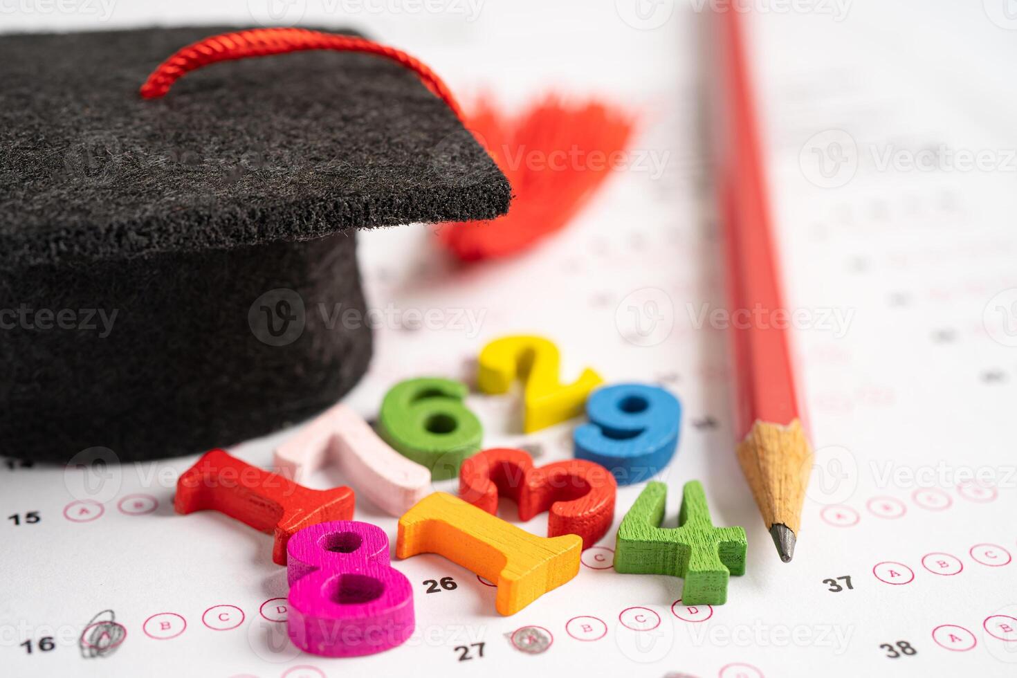 Graduation gap hat and pencil on answer sheet paper, Education study testing learning teach concept. photo