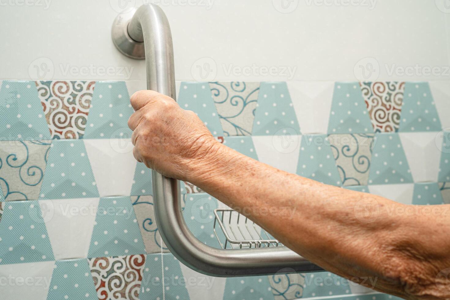 Asian elderly woman use bathroom handle security in toilet, healthy strong medical concept. photo