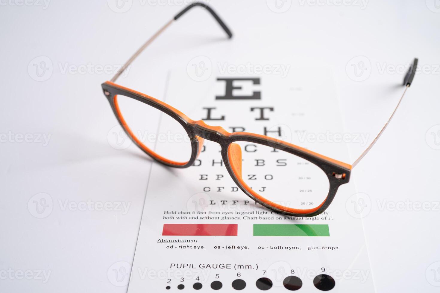 Glasses on eye testing exam chart to check eyesight accuracy of reading. photo