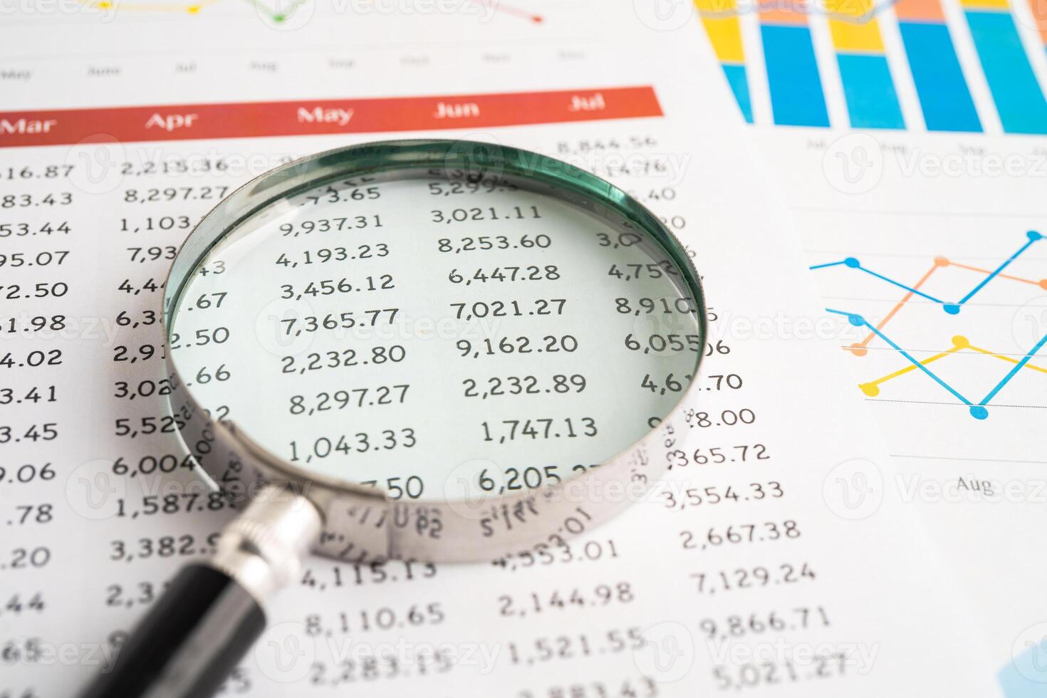 Magnifying glass on spreadsheet and graph paper. Financial development, Banking Account, Statistic, Investment Analytic research data economy, Business. photo