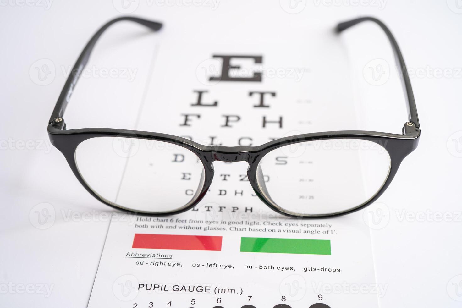 Glasses on eye testing exam chart to check eyesight accuracy of reading. photo