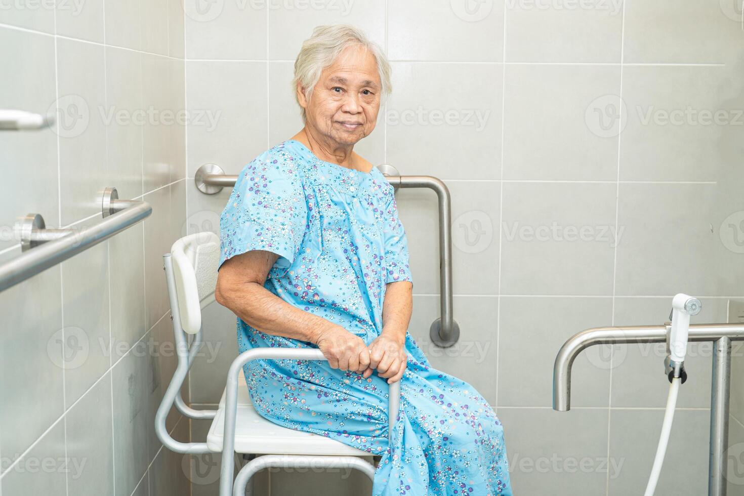 Asian elderly woman patient use toilet bathroom handle security in nursing hospital, healthy strong medical concept. photo