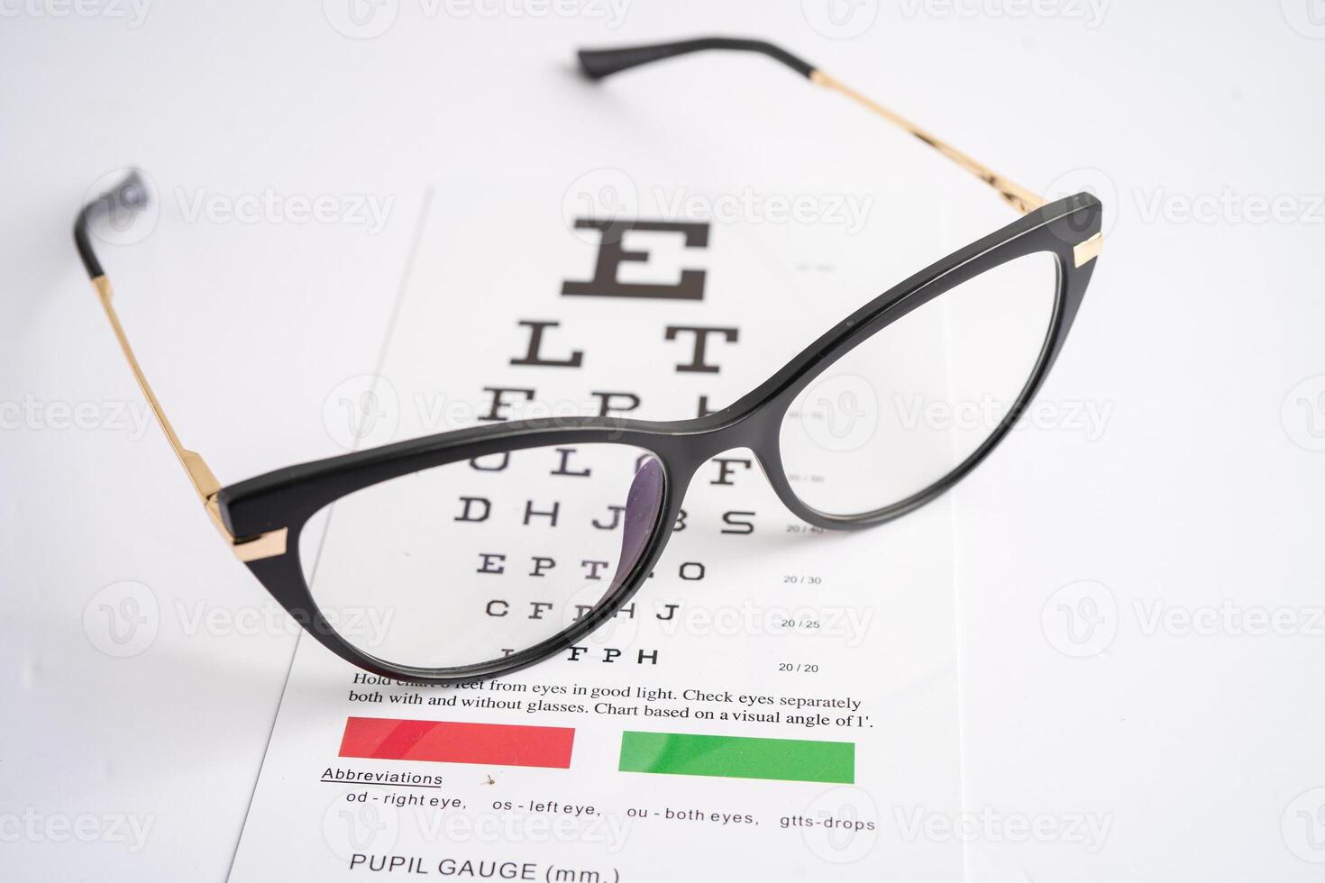 Glasses on eye testing exam chart to check eyesight accuracy of reading. photo