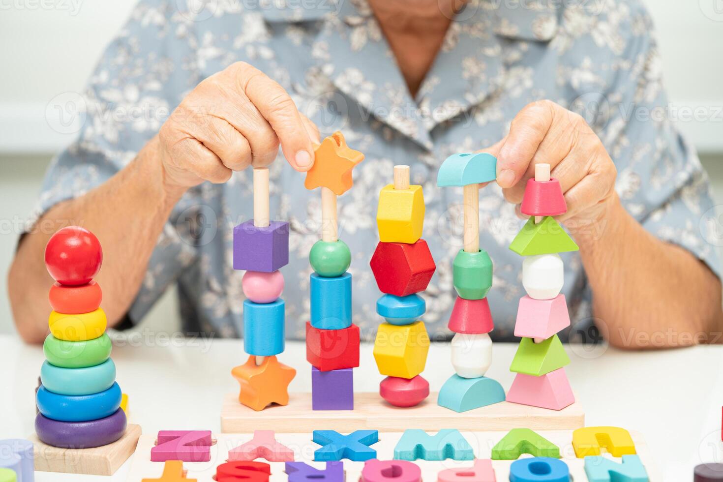 Alzheimer disease AD, Asian elderly woman patient suffering from dementia learn practical motor skills rehabilitation. photo