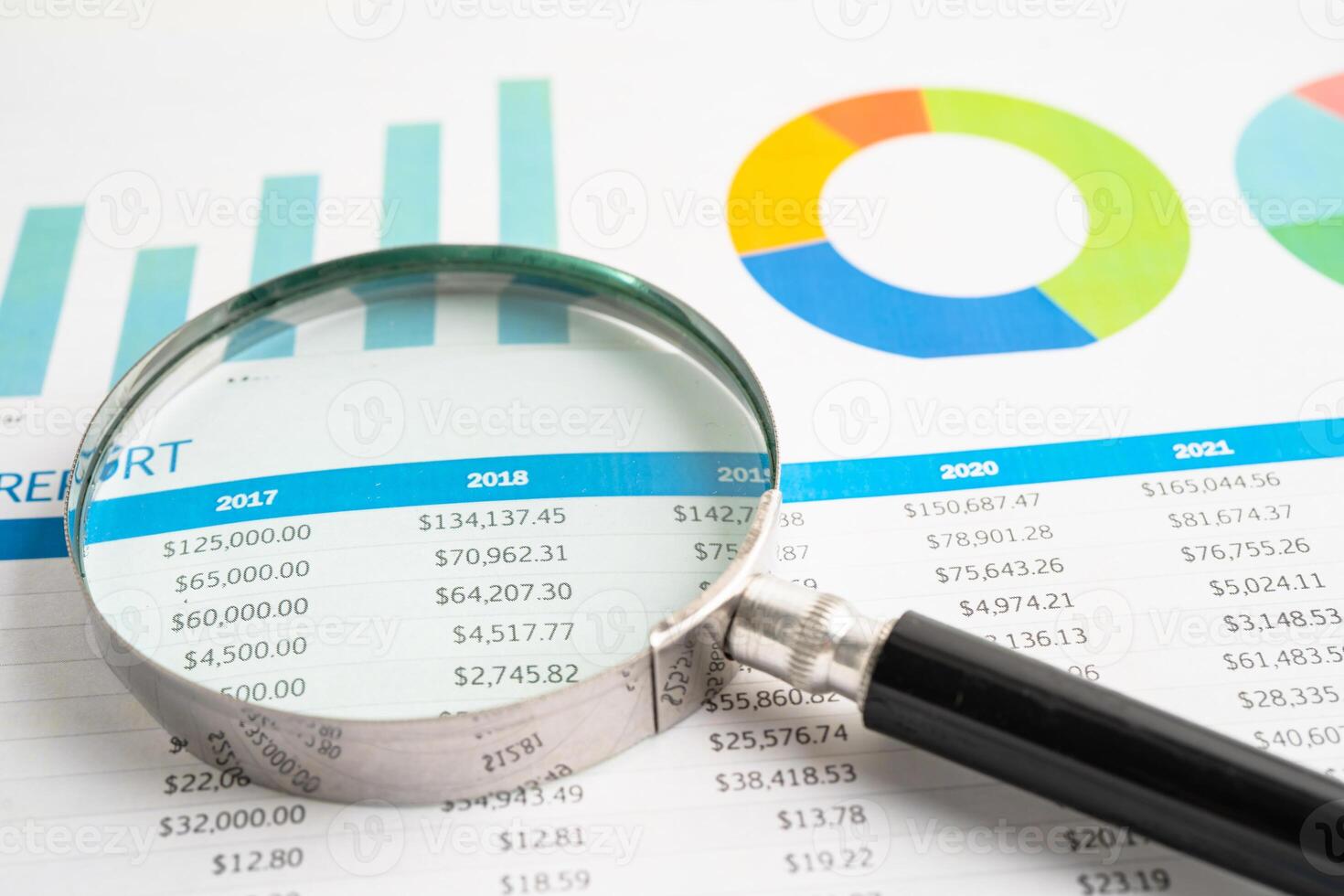 Magnifying glass on spreadsheet and graph paper. Financial development, Banking Account, Statistic, Investment Analytic research data economy, Business. photo