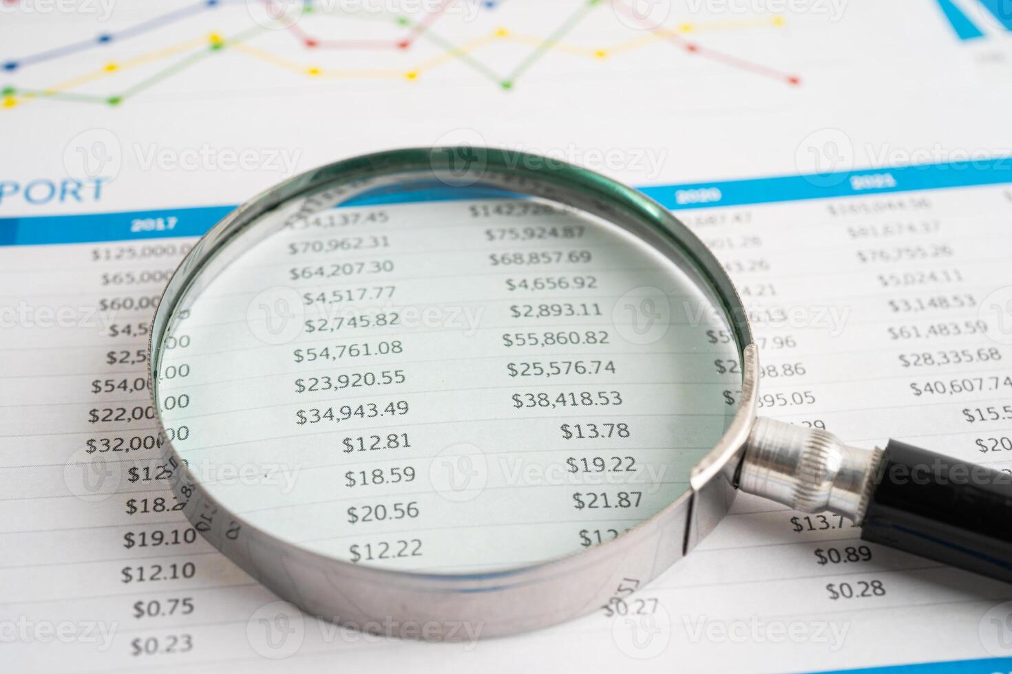 Magnifying glass on spreadsheet and graph paper. Financial development, Banking Account, Statistic, Investment Analytic research data economy, Business. photo