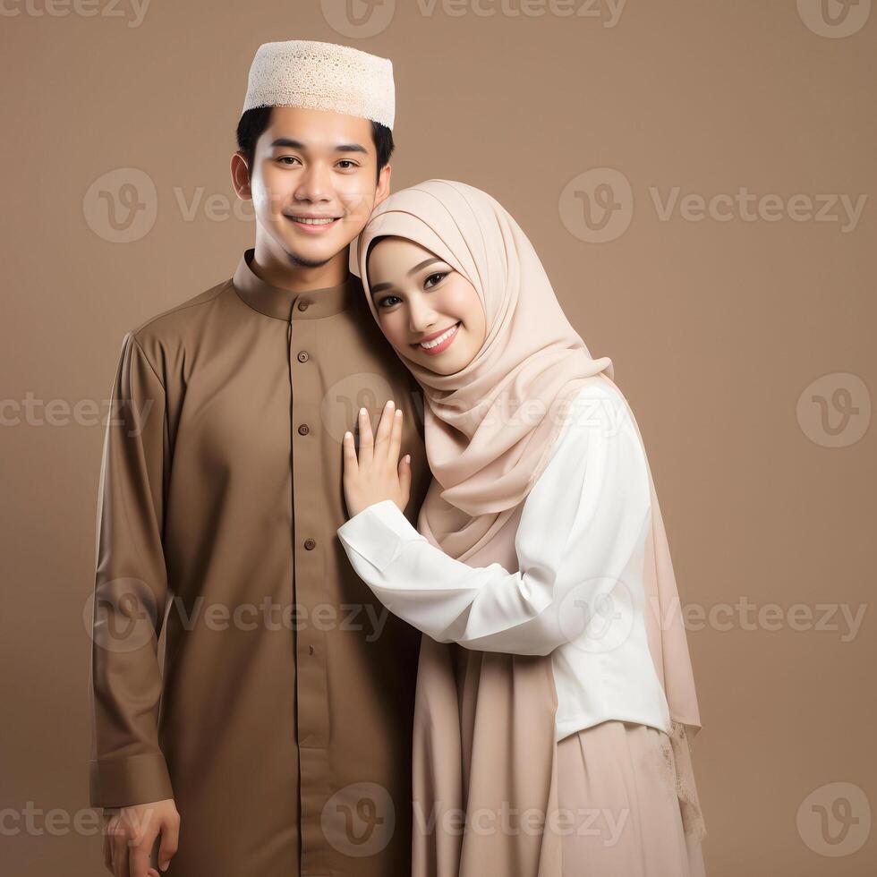 AI generated Heartwarming portrayal of a young Asian Muslim couple in traditional attire, including hijab, exchanging joyful Eid Mubarak gestures in a studio setting with a neutral color palette photo