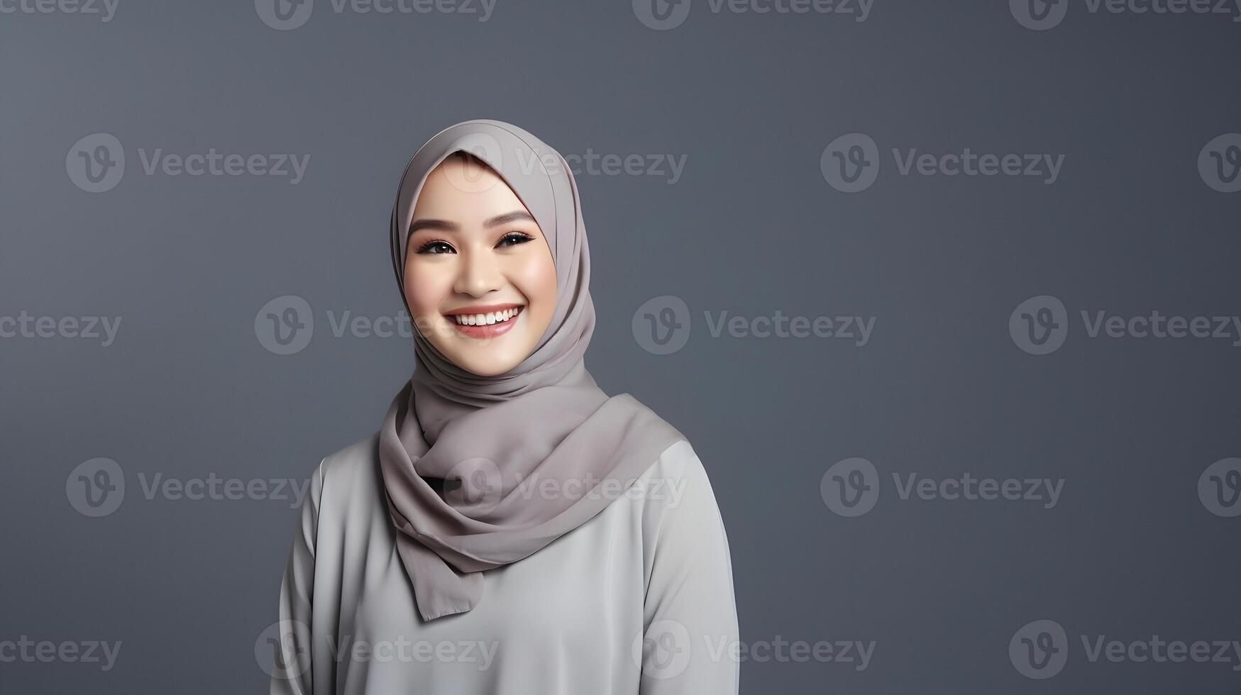 AI generated Radiant smile of a beautiful Asian woman with a hijab, capturing genuine joy and warmth, against a gray background photo