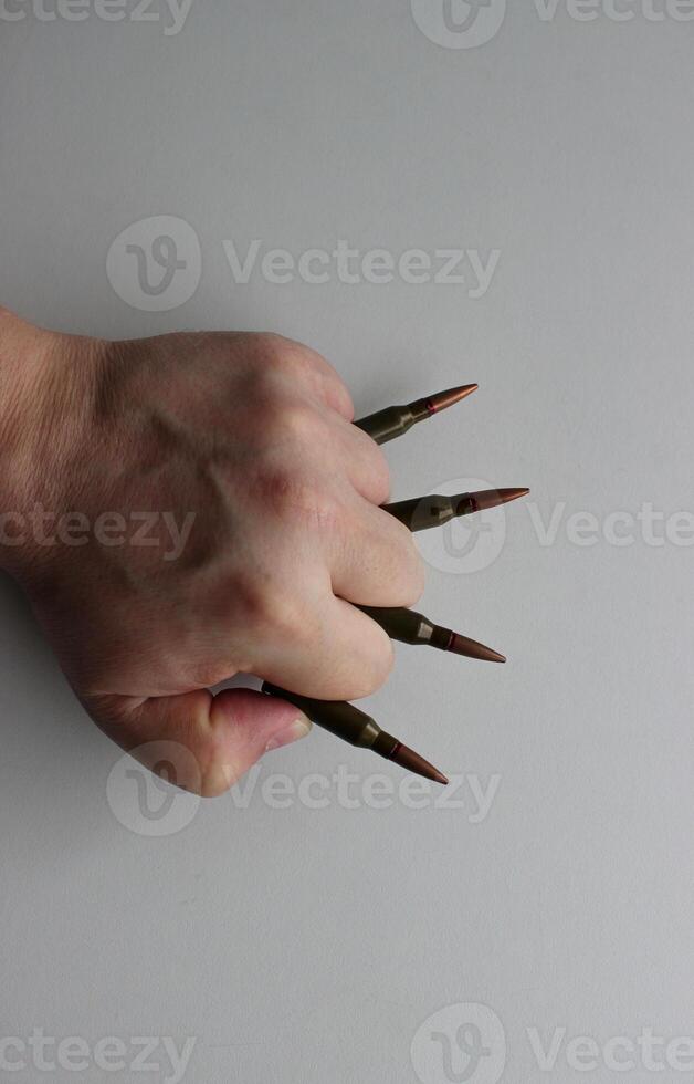 The bullets clamped in the fingers of the fist look like brass knuckles photo
