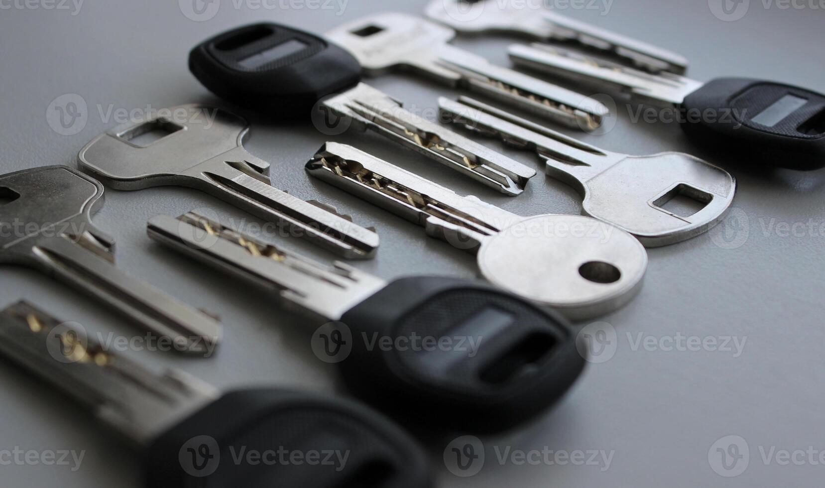 Angle view of keys with metal and plastic heads laid out on a white surface photo