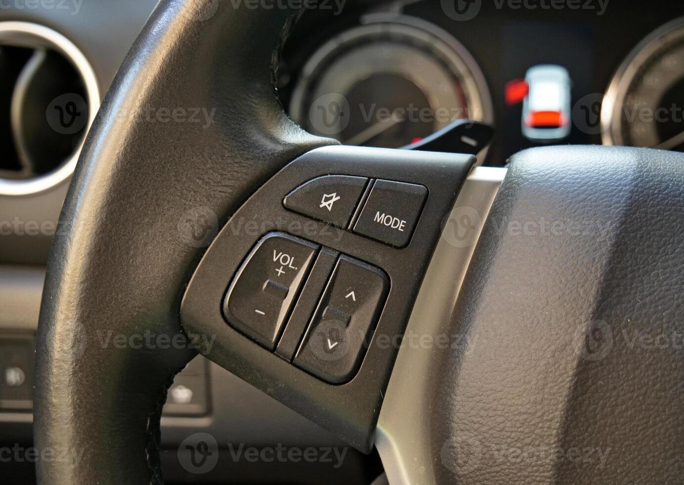 Steering Wheel With Control Buttons In Front Of Defocused Activated Open Door Safety Sign On A Car Dashboard photo
