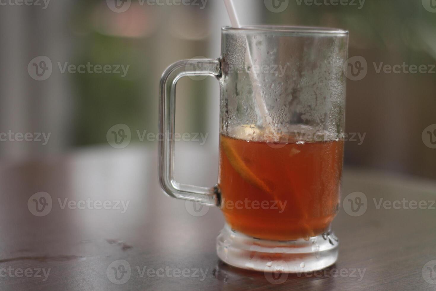 A glass of iced lemon tea on the table. Refreshing Iced Tea with Lemon, at the cafe. photo