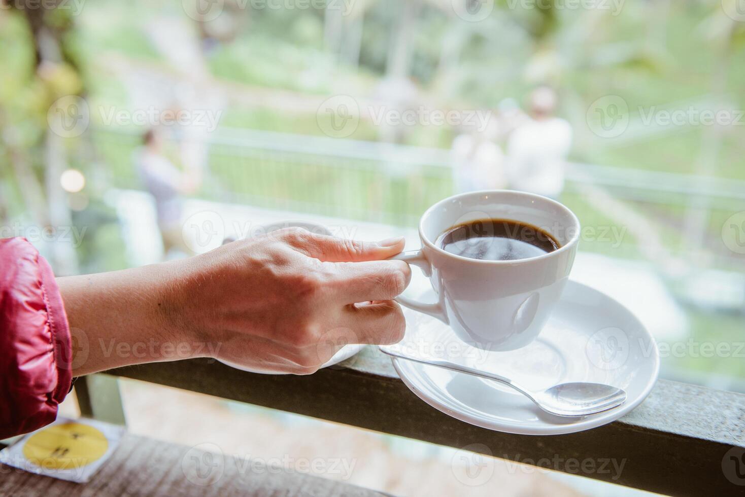 mujer mano participación un taza de caliente luwak café, uno de el más costoso café en el mundo en el café tienda en bali, Indonesia. foto