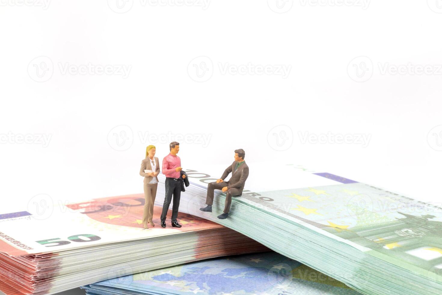 Miniature businessman navigates the financial landscape, surrounded by Euro banknotes, photo