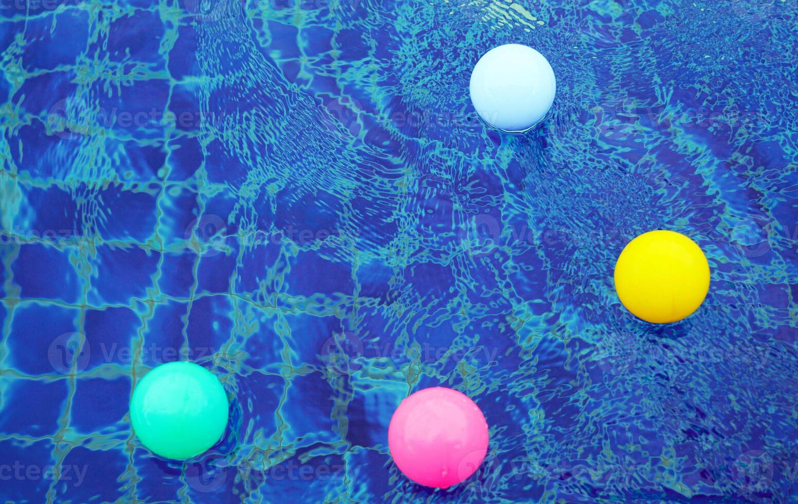 Top view of plastic balls floating on the surface of the water, bouncing up and down from the water waves, creating beautiful blue and white patterns. photo