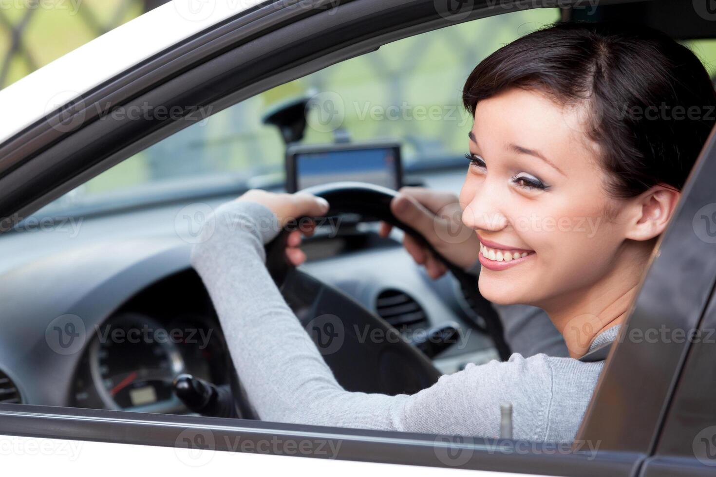 Pretty woman driver happily laughing in a car, closeup shot photo