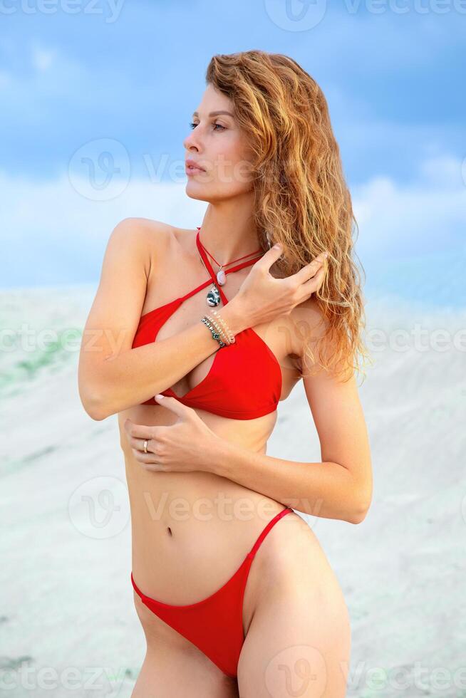 Beautiful young woman in red bikini on the beach at Maldives photo