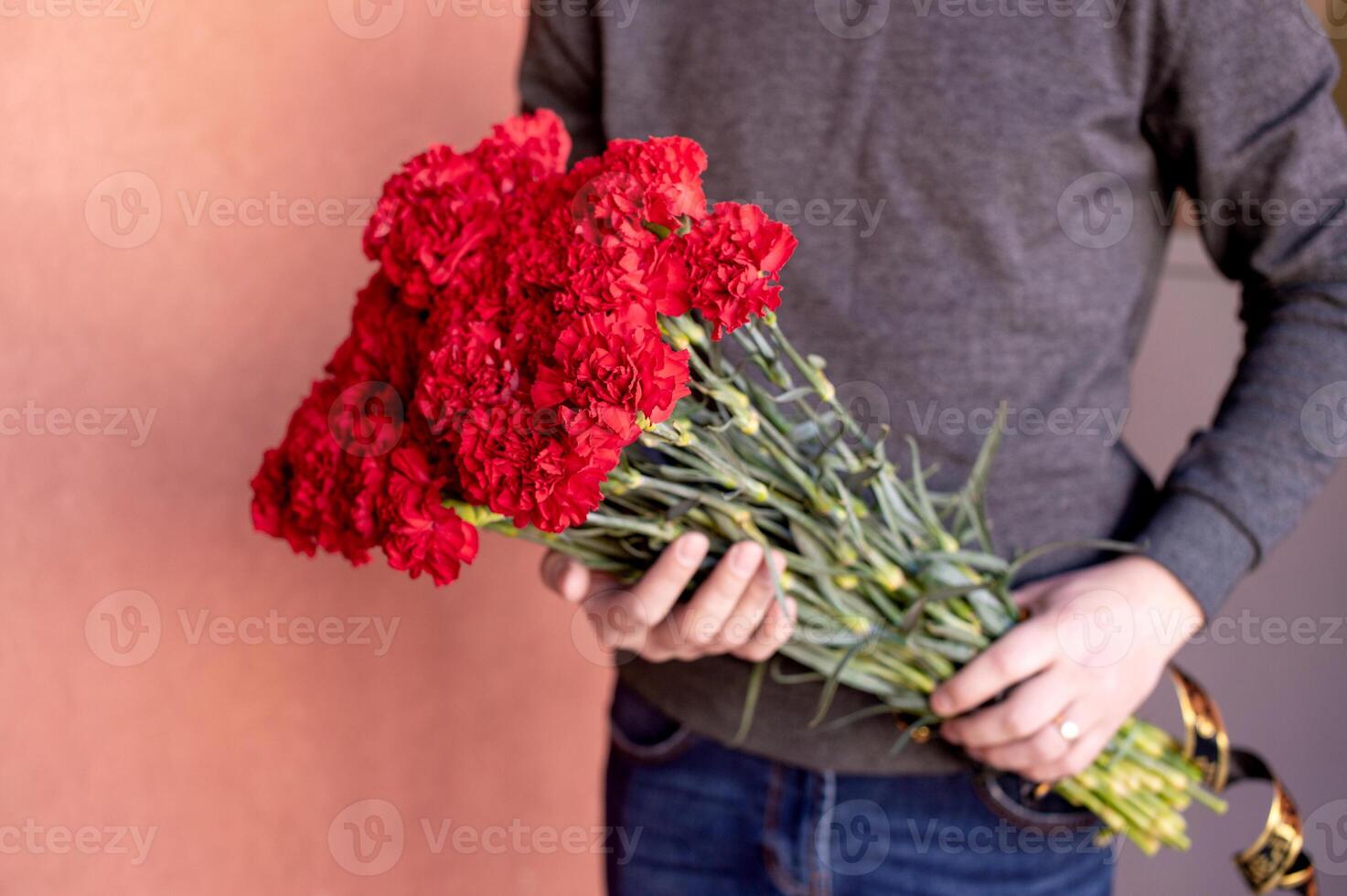 Funeral bouquet of red carnations with in the hands of a man photo