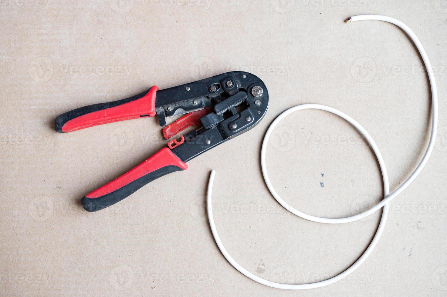Crimping Tool and Coaxial Cable on Cardboard photo