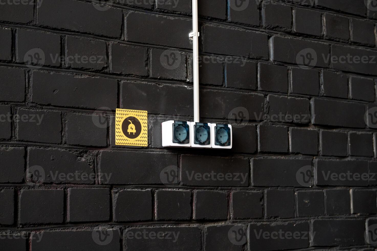 Electrical Outlets on Black Brick Wall photo