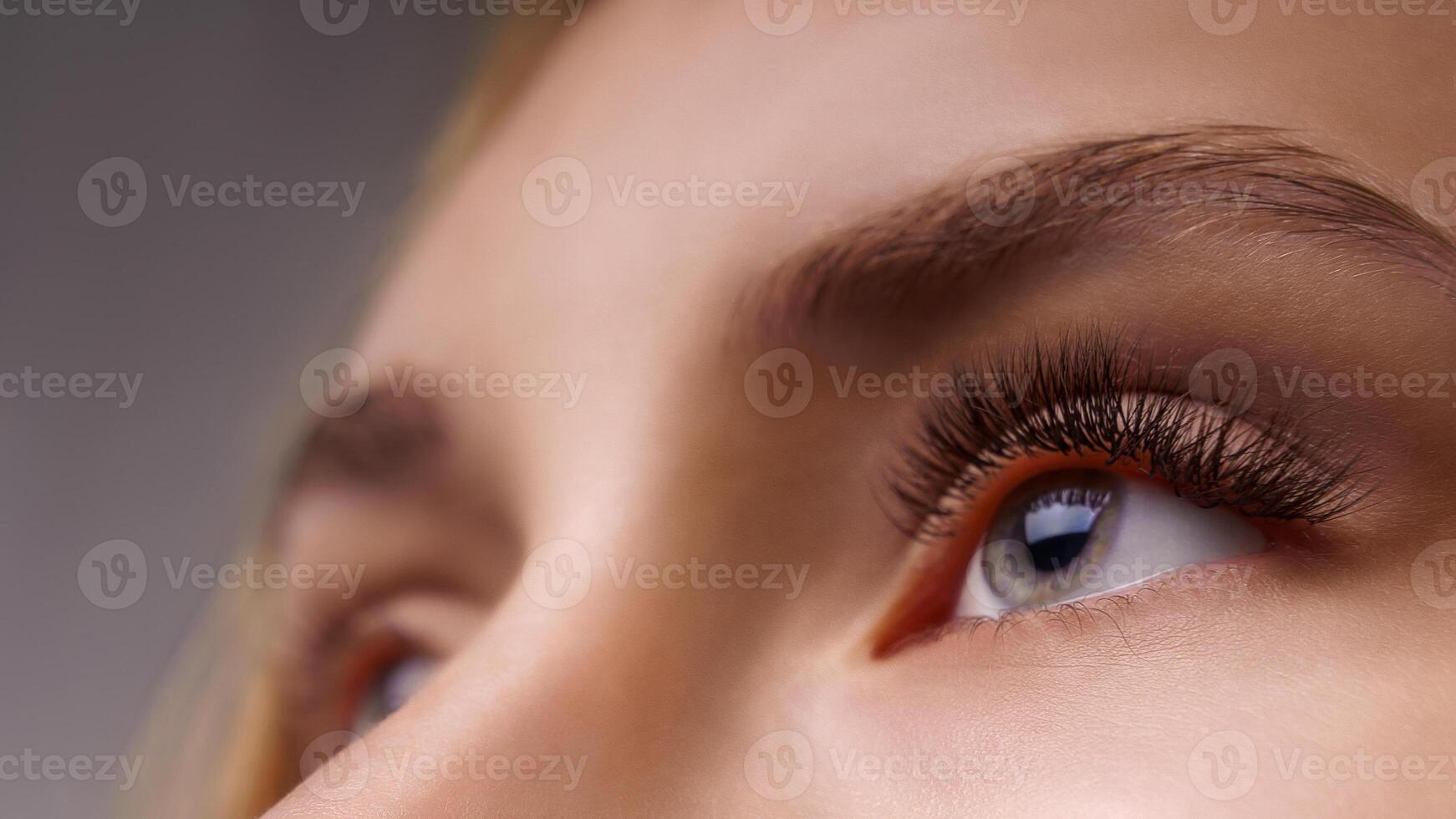 Eyelash Extension Procedure. Woman Eye with Long Eyelashes. Close up, selective focus. photo