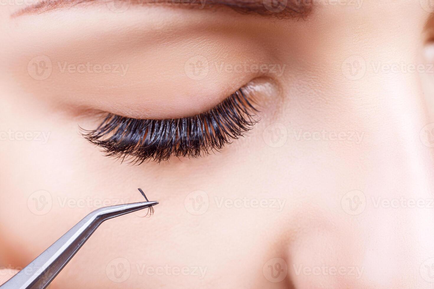 Eyelash Extension Procedure. Woman Eye with Long Eyelashes. Lashes, close up, macro, selective focus. photo