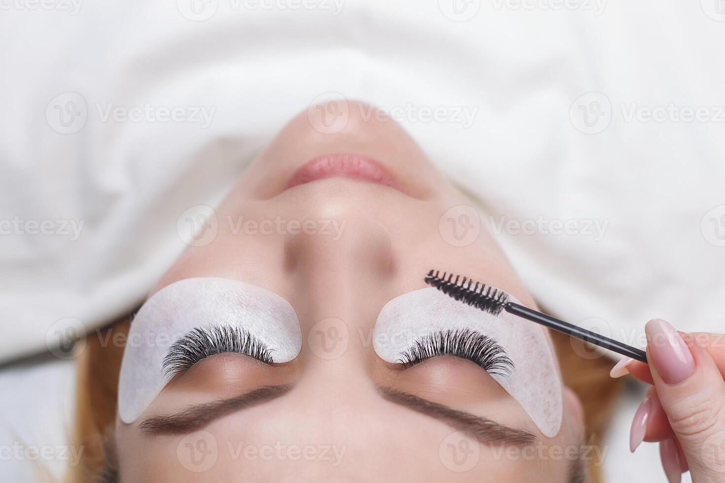 Eyelash Extension Procedure. Woman Eye with Long Eyelashes. Lashes, close up, selected focus. photo