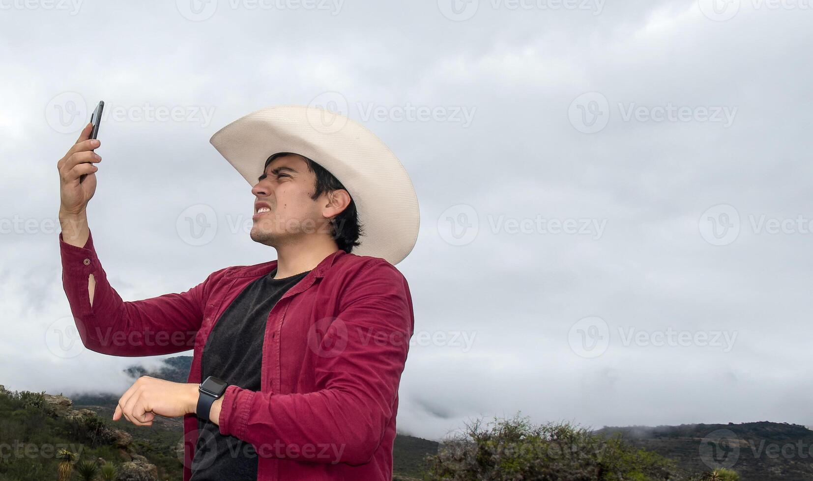 Ranch man with his phone searching for signal in rural area photo