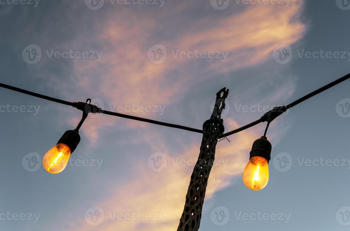 Vintage old light bulbs with sky background at sunset photo