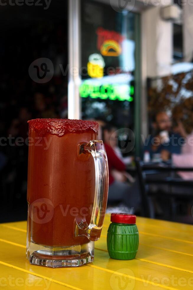 Michelada, Mexican drink of beer, clamato, salda, lemon and chamoy, with space for text photo