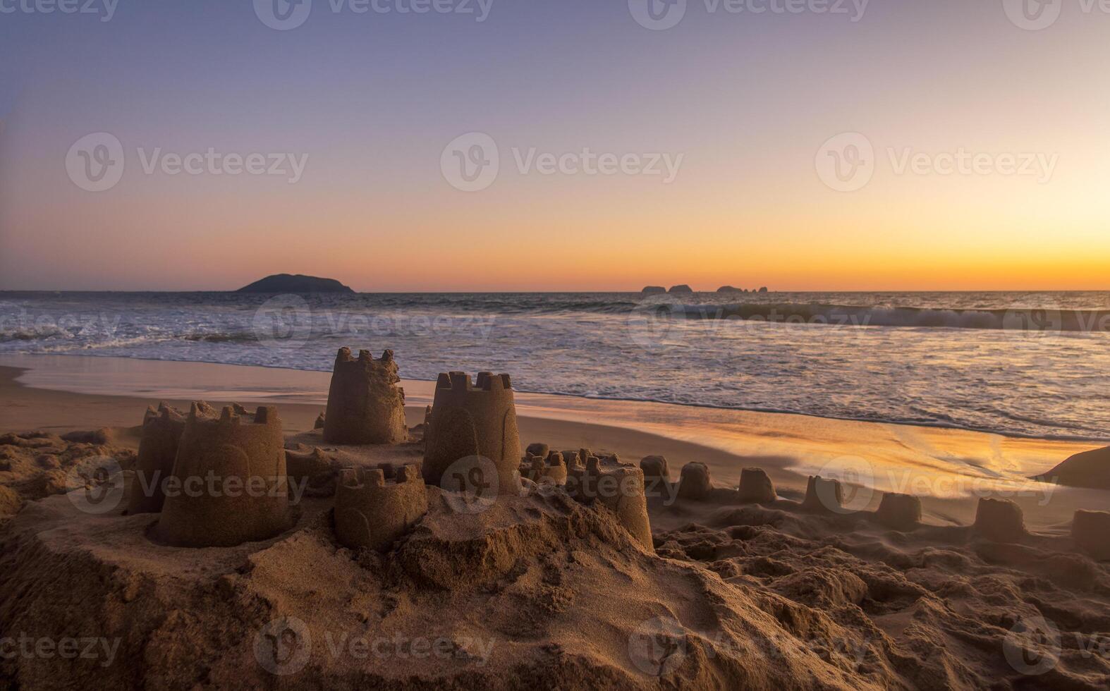 Sand castle on the beach during sunset with space for text photo