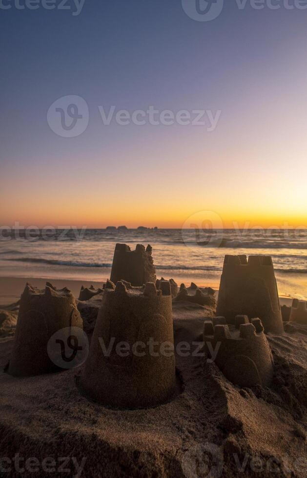 Sand castle made by children on the beach with beautiful sunset on the beach, with space for text photo