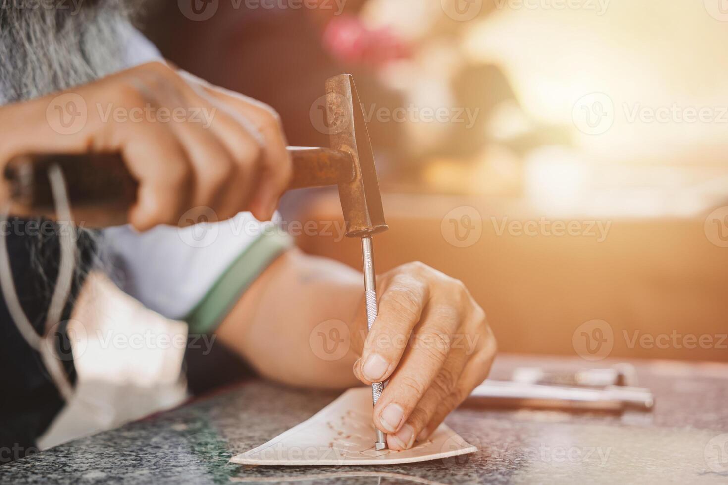 de cerca mano trabajando proceso cuero artesanía en el cuero taller. hombre participación elaboración herramienta y laboral. él es de coser martillo a hacer un billetera. curtidor en antiguo curtiduría. foto