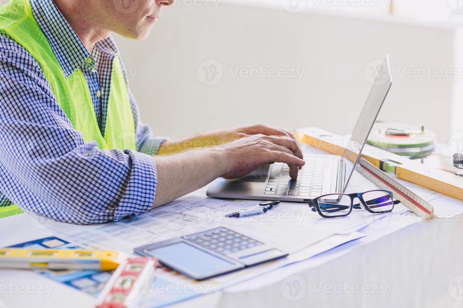 construcción ingeniero constructor trabajando a escritorio mecanografía en ordenador portátil computadora. personas utilizando movilidad 5g Internet inalámbrico conexión. foto