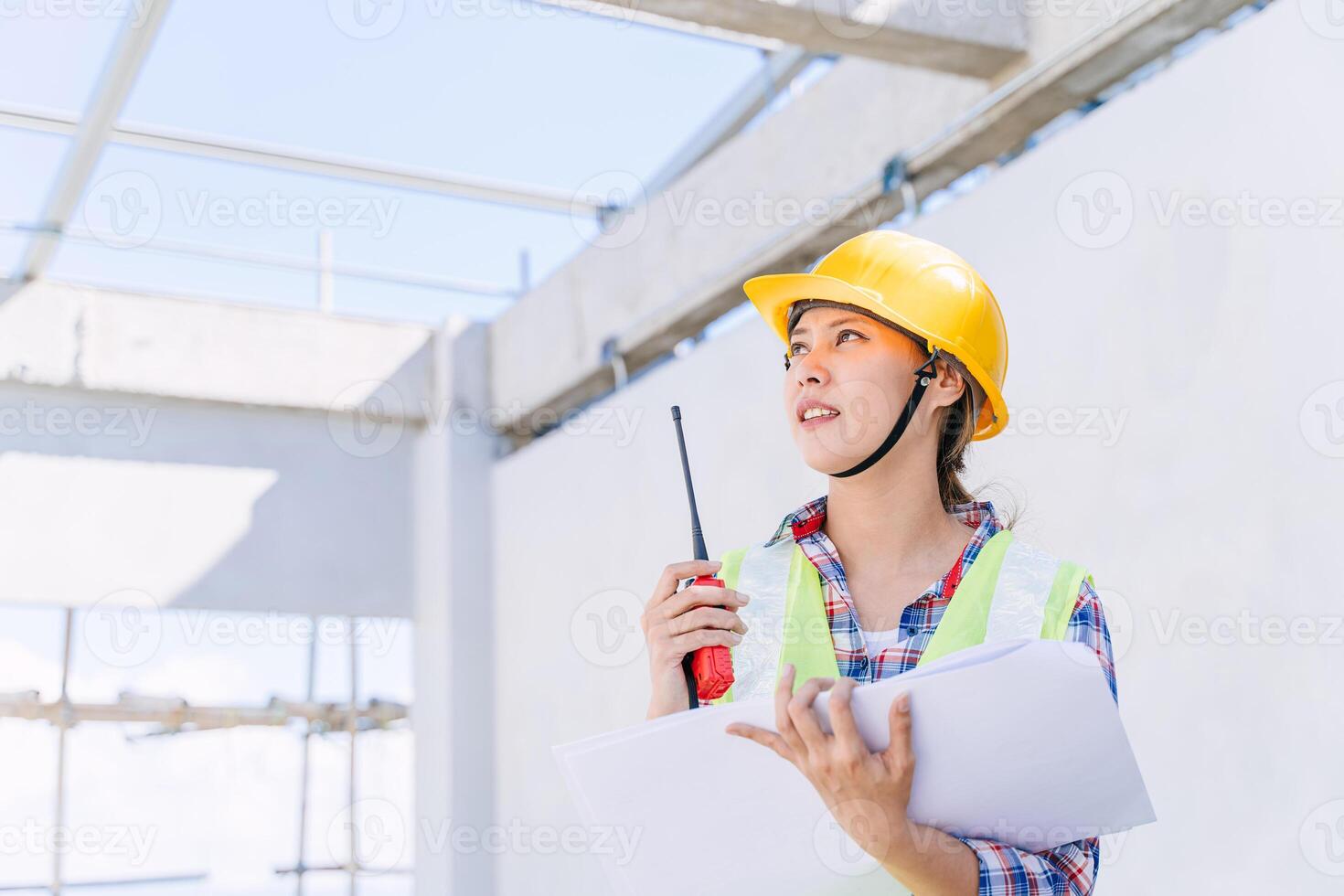 Asian woman engineer worker work in construction site. Smart builder architect female in safety suite working. photo