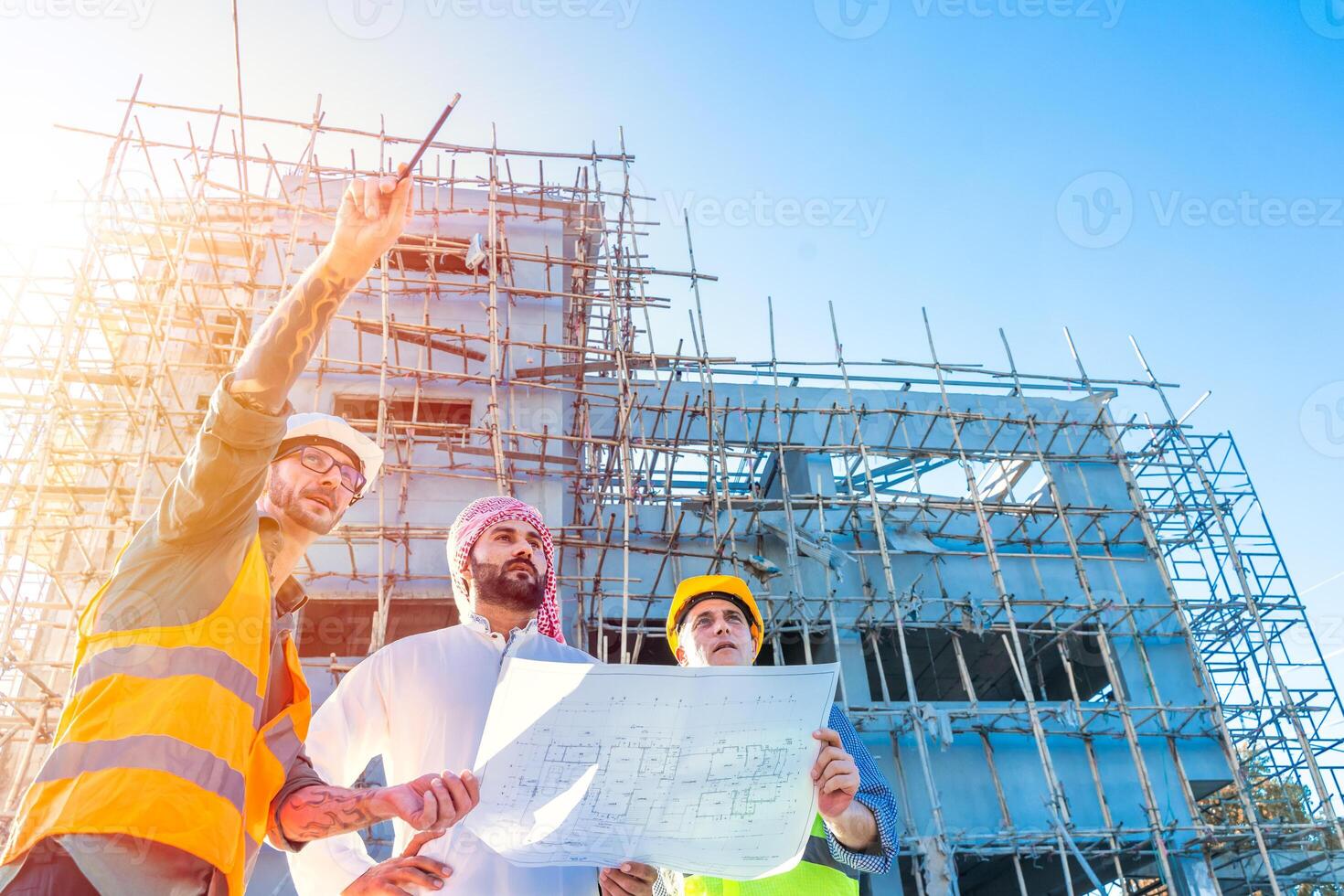 Engineer team group with Arab business estate project manager check floor plan of building at construction site photo